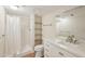 Bathroom featuring a walk-in shower, wooden shelves, vanity, and mirror at 2753 Orchid Oaks Dr # 104, Sarasota, FL 34239