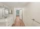 Bathroom featuring a double vanity, mirror, and wood-look flooring at 2753 Orchid Oaks Dr # 104, Sarasota, FL 34239