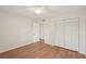 Bedroom with wood floors, ceiling fan, bifold closet, and a white door at 2753 Orchid Oaks Dr # 104, Sarasota, FL 34239