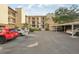 Condominium building exterior featuring a parking lot and covered parking spaces at 2753 Orchid Oaks Dr # 104, Sarasota, FL 34239