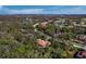 An aerial view of a serene residential area with lush greenery, golf course, and lake at 3178 Dick Wilson Dr, Sarasota, FL 34240