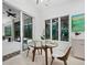 Cozy dining area with glass-top table, modern chairs, and view of tropical foliage at 3178 Dick Wilson Dr, Sarasota, FL 34240