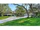Stunning ranch-style home featuring a circular driveway, lush landscaping, and mature trees providing ample shade at 3178 Dick Wilson Dr, Sarasota, FL 34240