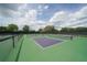 View of well-maintained community pickleball courts surrounded by mature trees and black fencing at 3178 Dick Wilson Dr, Sarasota, FL 34240