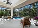 Inviting enclosed pool area with comfortable seating, dining space, and lush greenery creating a tranquil and private oasis at 3178 Dick Wilson Dr, Sarasota, FL 34240