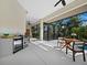 The screened pool area features an outdoor kitchen and dining space with lush, tropical views at 3178 Dick Wilson Dr, Sarasota, FL 34240