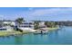 Wide view of a waterfront home, boat dock, and beautiful landscaping on the water in a residential neighborhood at 3638 San Remo Ter, Sarasota, FL 34239