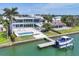Aerial view of a modern waterfront home with a private pool, boat lift, and dock on a sunny day at 3638 San Remo Ter, Sarasota, FL 34239
