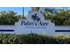 Palm Aire: A Private Country Club community entrance sign nestled among mature trees and lush greenery at 7030 W Country Club N Dr # 128, Sarasota, FL 34243