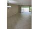 Open living room with neutral walls, sliding glass doors, and tile flooring at 7030 W Country Club N Dr # 128, Sarasota, FL 34243