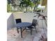 Cozy patio features a round dining table and chairs with tropical landscaping, perfect for relaxing outdoors at 7030 W Country Club N Dr # 128, Sarasota, FL 34243
