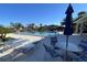 Community pool area with chairs and umbrella-covered tables at 7030 W Country Club N Dr # 128, Sarasota, FL 34243