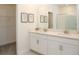 Bright bathroom featuring a white double sink vanity, modern fixtures, framed art and a glass-enclosed shower at 12525 Lily Quartz Loop, Parrish, FL 34219