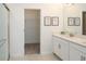 Bright bathroom featuring a white double sink vanity, modern fixtures, framed art and a glass-enclosed shower at 12525 Lily Quartz Loop, Parrish, FL 34219