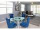 Stylish dining area with glass table, blue velvet chairs, and a view into the comfortable living room at 12525 Lily Quartz Loop, Parrish, FL 34219