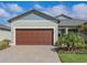 Charming home featuring a well-maintained lawn, a large garage, and a beautiful paver driveway at 12525 Lily Quartz Loop, Parrish, FL 34219