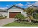 Beautiful home with a large garage, lush lawn, and lovely landscaping including a palm tree at 12525 Lily Quartz Loop, Parrish, FL 34219