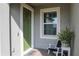 Inviting front porch with a green door, white trim, and a chair perfect for enjoying the outdoors at 12525 Lily Quartz Loop, Parrish, FL 34219