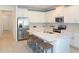 Eat-in kitchen with a view of stainless steel appliances, white cabinets, and long breakfast bar at 12525 Lily Quartz Loop, Parrish, FL 34219
