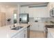 Bright kitchen with stainless steel appliances, white cabinetry, and long island with a view to the living area at 12525 Lily Quartz Loop, Parrish, FL 34219