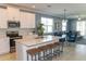 Modern kitchen with stainless steel appliances, white cabinets, an island and a view of the dining and living area at 12525 Lily Quartz Loop, Parrish, FL 34219