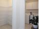 Convenient laundry room with a washer, dryer, and ample shelving for storage, offering practicality and organization at 12525 Lily Quartz Loop, Parrish, FL 34219