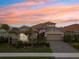 Beautiful exterior of home with paver driveway, 2 car garage, manicured lawn, and a flagpole showing the American flag at 20296 Bandera Pl, Venice, FL 34293