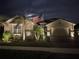 Beautiful exterior of home with paver driveway, 2 car garage, manicured lawn, and a flagpole showing the American flag at 20296 Bandera Pl, Venice, FL 34293