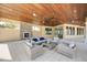 Inviting outdoor lounge area with comfortable seating, fireplace and a wooden ceiling at 20296 Bandera Pl, Venice, FL 34293