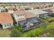 Aerial view of backyard featuring screened-in pool, lush landscaping, patio area and neighborhood setting at 20296 Bandera Pl, Venice, FL 34293