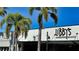Front exterior of Libby's Neighborhood Brasserie with palm trees against a blue sky at 2264 Floyd St, Sarasota, FL 34239