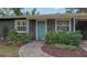 Charming home entrance with a lovely blue door and a welcoming brick pathway surrounded by beautiful landscaping at 2264 Floyd St, Sarasota, FL 34239