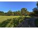 A sprawling green lawn with mature trees and a paved path invites leisurely strolls and outdoor activities at 2264 Floyd St, Sarasota, FL 34239