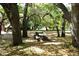 Leaf covered ground with picnic tables surrounded by mature trees in a shady picnic area at 2264 Floyd St, Sarasota, FL 34239
