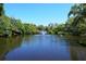 Scenic pond with a fountain and lush green trees under a clear blue sky at 2264 Floyd St, Sarasota, FL 34239