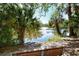 A view of a fountain on the pond, partially obscured by palm trees and with a bench in the foreground at 2264 Floyd St, Sarasota, FL 34239
