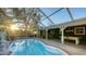 Backyard oasis featuring a sparkling pool, screened enclosure, and covered patio with lounging area at 2264 Floyd St, Sarasota, FL 34239