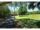 Winding paved path through a green park with a vintage light post and shady trees at 2264 Floyd St, Sarasota, FL 34239