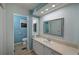 Well-lit bathroom with a long vanity, mirrors, and an adjacent toilet area at 4531 13Th E St, Ellenton, FL 34222