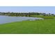 Serene lake view with lush green shoreline and landscaping at 4531 13Th E St, Ellenton, FL 34222