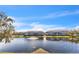 Scenic view of condo buildings overlooking a serene lake with a fountain under a clear blue sky at 4802 51St W St # 521, Bradenton, FL 34210