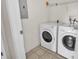 Functional laundry room featuring a white washer and dryer set with tile flooring and shelving at 4802 51St W St # 521, Bradenton, FL 34210