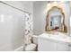 Bathroom featuring a shower/tub, stylish mirror, white vanity, and a floral shower curtain at 517 Blue Heron Dr, Anna Maria, FL 34216