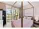 Beautiful bedroom with a four poster bed and a private balcony overlooking the water at 517 Blue Heron Dr, Anna Maria, FL 34216