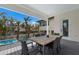 Inviting outdoor dining area with weathered wood table overlooking the refreshing pool and tropical landscaping at 6605 Gulf Dr, Holmes Beach, FL 34217