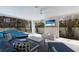 Inviting outdoor living space with a plush lounge area, fire feature, and TV overlooking the pool at 6605 Gulf Dr, Holmes Beach, FL 34217