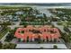 Stunning aerial view of the condos with red tile roofs near lush landscaping, and waterways nearby at 800 S Blvd Of Presidents # 12, Sarasota, FL 34236