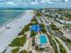 Coastal view of a beachside complex featuring an oceanfront public pool, parking, and sandy beach at 800 S Blvd Of Presidents # 12, Sarasota, FL 34236