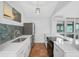 Modern kitchen with stainless steel appliances, white cabinetry, and a stylish backsplash at 800 S Blvd Of Presidents # 12, Sarasota, FL 34236