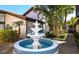 Charming community water feature with blue mosaic tile, tropical landscaping, and swaying palm trees at 800 S Blvd Of Presidents # 12, Sarasota, FL 34236